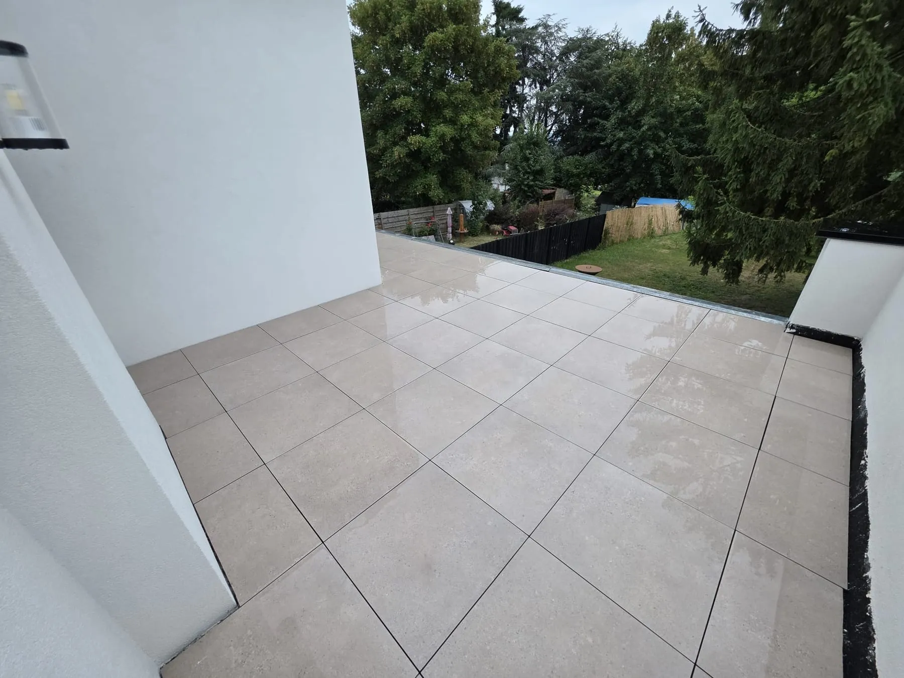 Dalles céramiques grand format, joints réguliers, surface plane sur toute la terrasse.